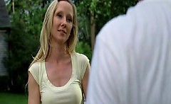 Anne Heche pulling herself up onto a dock beside a lake at