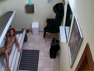 Red MILF rubs her pussy in solarium