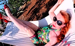 Red XXX stuffs her pussy with a toy in the hammock